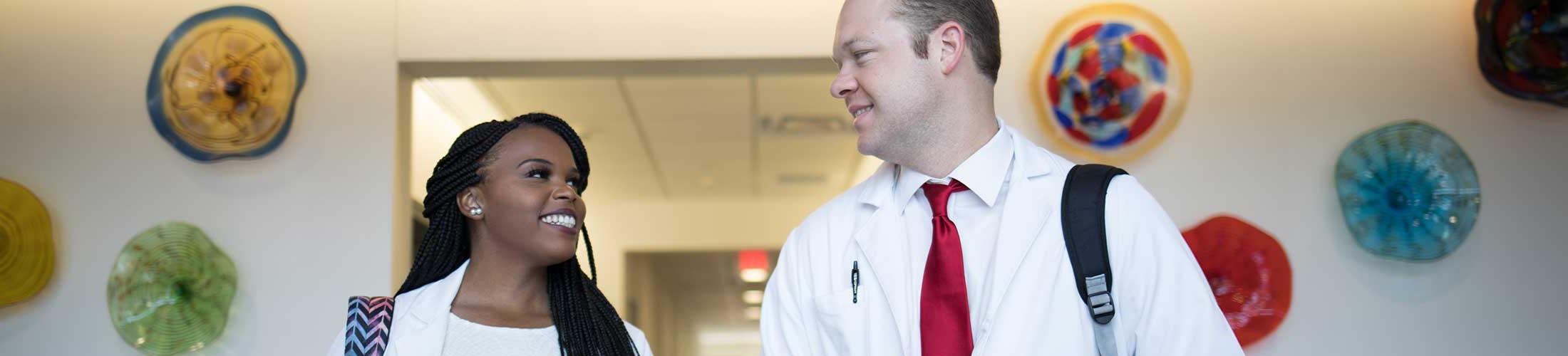 Two Physician Assistant Studies student walking in the Allied Health building.